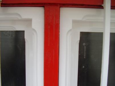 detalle de ventanas para puerta de forja hechas en madera de pino lacada en blanco